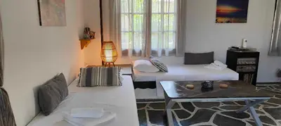 a living room with two beds and a table at Sylvia's house at Vagia in Vaia
