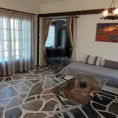 a bedroom with a bed and a table in it at Sylvia's house at Vagia in Vaia