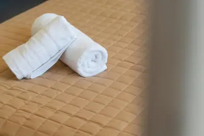 a white towel sitting on top of a bed at Harmony 2BR Apartment in Athens in Athens