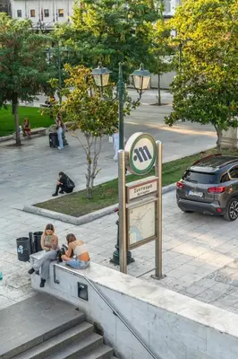 two people sitting on the stairs next to a sign at Harmony 2BR Apartment in Athens in Athens