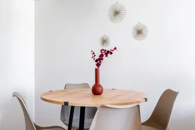 a wooden table with a vase with flowers in it at Harmony 2BR Apartment in Athens in Athens