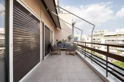 a balcony with a table and chairs on a building at All time Classic: Pianist's 5th FL Apt @ Acropolis in Athens