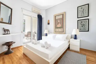 a white bedroom with a large white bed and a window at All time Classic: Pianist's 5th FL Apt @ Acropolis in Athens