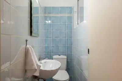 a blue tiled bathroom with a toilet and a sink at All time Classic: Pianist's 5th FL Apt @ Acropolis in Athens