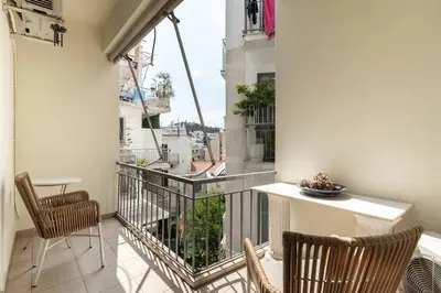 a balcony with two chairs and a table on a building at All time Classic: Pianist's 5th FL Apt @ Acropolis in Athens