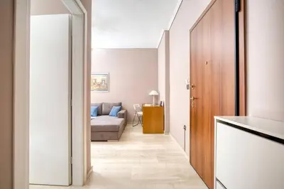 a hallway leading to a living room with a couch at Μοντέρνο διαμέρισμα 2' από το μετρό in Athens