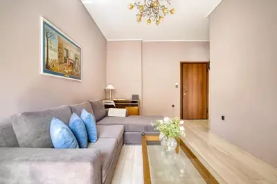 a living room with a gray couch and blue pillows at Μοντέρνο διαμέρισμα 2' από το μετρό in Athens
