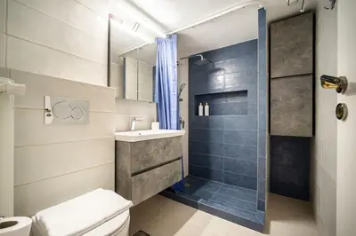 a bathroom with a toilet and a sink and a shower at Μοντέρνο διαμέρισμα 2' από το μετρό in Athens