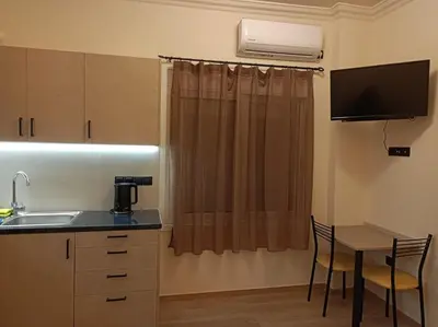 a kitchen with a sink and a table with chairs at Apartment Dipla in Athens