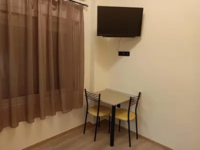 a table with two chairs and a television on a wall at Apartment Dipla in Athens