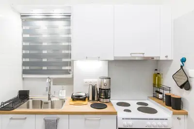 a white kitchen with a sink and a stove at Sweet greek memories-Acropolis in Athens