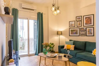 a living room with a green couch and a table at Sweet greek memories-Acropolis in Athens