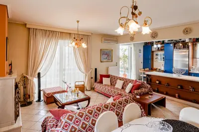 a living room with a couch and a table at Pantheon Penthouse, Athens Riviera in Athens