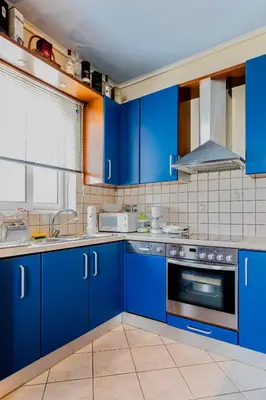 a blue kitchen with blue cabinets and appliances at Pantheon Penthouse, Athens Riviera in Athens