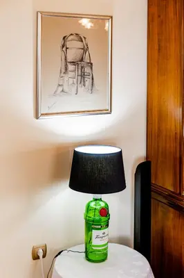 a lamp on a table with a bottle on it at Pantheon Penthouse, Athens Riviera in Athens