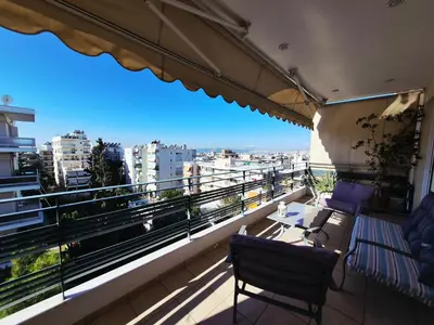 a balcony with two chairs and a table and a view at Pantheon Penthouse, Athens Riviera in Athens
