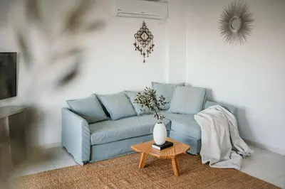 a living room with a blue couch and a table at Greek Sea Villas Kaki Thalassa 400m to the beach ,Athens in Keratea