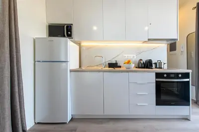 a kitchen with white cabinets and a white refrigerator at Beautiful loft close to Acropolis in Athens