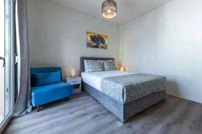a bedroom with a bed and a blue chair at Beautiful loft close to Acropolis in Athens