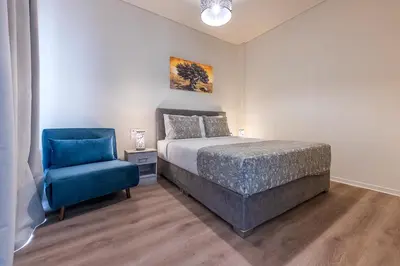 a bedroom with a bed and a blue chair at Beautiful loft close to Acropolis in Athens