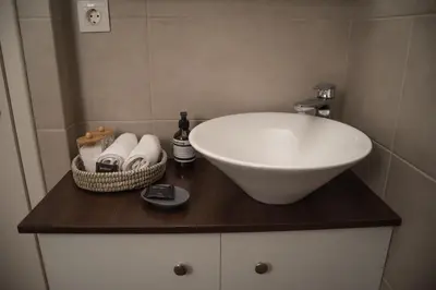 a bathroom with a sink and towels on a counter at Naiads Nest - The Blue Wave in Varkiza