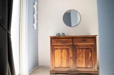 a mirror over a wooden cabinet in a room at Naiads Nest - The Blue Wave in Varkiza