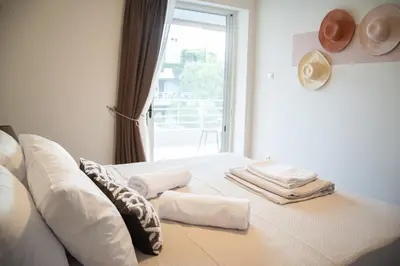 a bedroom with a bed with towels and a window at Naiads Nest - The Cozy Retreat in Varkiza