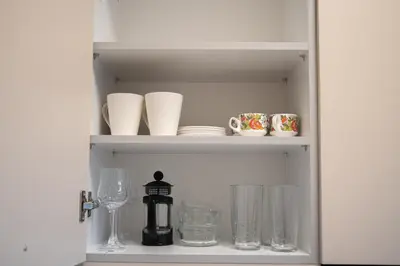 a cupboard filled with glasses and wine glasses at Naiads Nest - The Cozy Retreat in Varkiza
