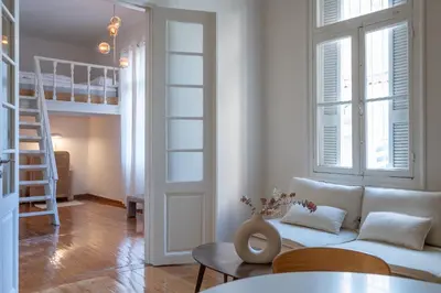 a living room with a white couch and a loft at Cream in Athens