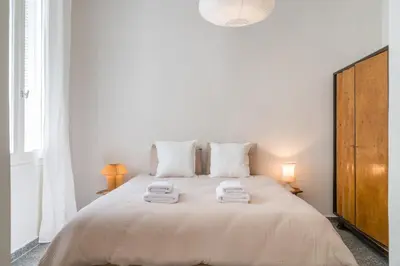 a white bedroom with a large bed with towels on it at Bill in Athens