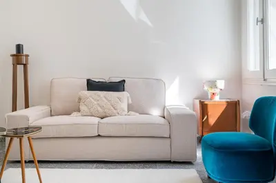 a living room with a white couch and blue chairs at Bill in Athens
