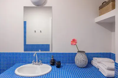 a bathroom with a sink and a vase with a flower at Bill in Athens