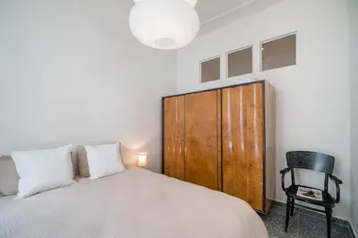 a bedroom with a bed and a wooden cabinet at Bill in Athens
