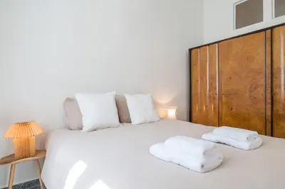 a bedroom with a white bed with two towels on it at Bill in Athens