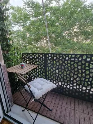 a chair and a table on a wooden deck at Piraeus open view Appartment in Piraeus