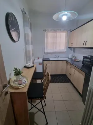 a kitchen with a table and chairs and a clock at Piraeus open view Appartment in Piraeus