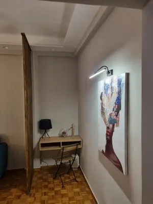 a desk in a room with a painting on the wall at Piraeus open view Appartment in Piraeus