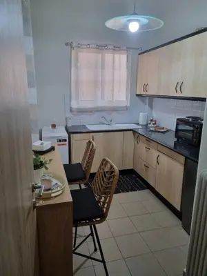 a kitchen with a table and two chairs and a counter at Piraeus open view Appartment in Piraeus