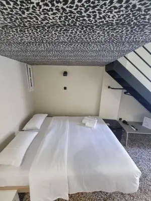 a large white bed in a room with a ceiling at 7ATHENS in Athens