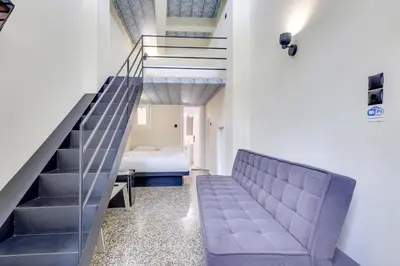 a staircase in a room with a couch and a bed at 7ATHENS in Athens