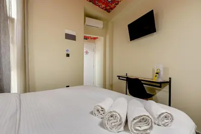 a bedroom with a white bed with towels on it at 7ATHENS in Athens