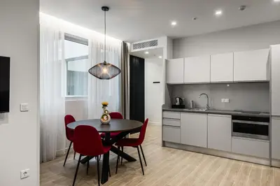 a kitchen and dining room with a table and red chairs at Hestia - Averof 7 in Athens