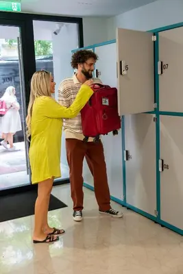 a woman is helping a man with a suitcase at Hestia - Averof 7 in Athens