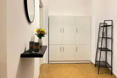 a room with white cabinets and a table and a shelf at Pame Rentals - Ideal For 4 in Pagrati in Athens