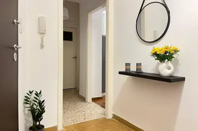 a hallway with a mirror and a vase with flowers on a shelf at Pame Rentals - Ideal For 4 in Pagrati in Athens