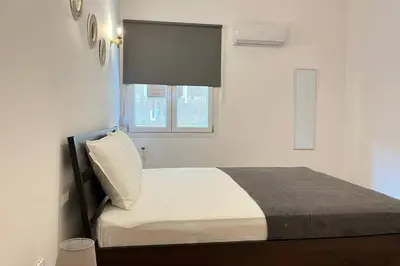 a small bedroom with a bed with a window at Pame Rentals - Ideal For 4 in Pagrati in Athens