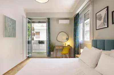 a bedroom with a bed and a desk with a yellow chair at Pausaniou8 in Athens