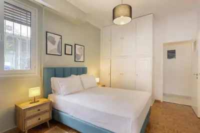 a bedroom with a white bed and a window at Pausaniou8 in Athens
