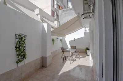 a hallway with white walls and a table and chairs at Marina Zeas Hidden Gem in Piraeus