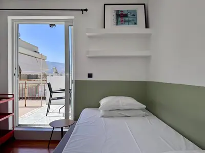 a bedroom with a bed and a sliding glass door at Athenian Sky in Athens